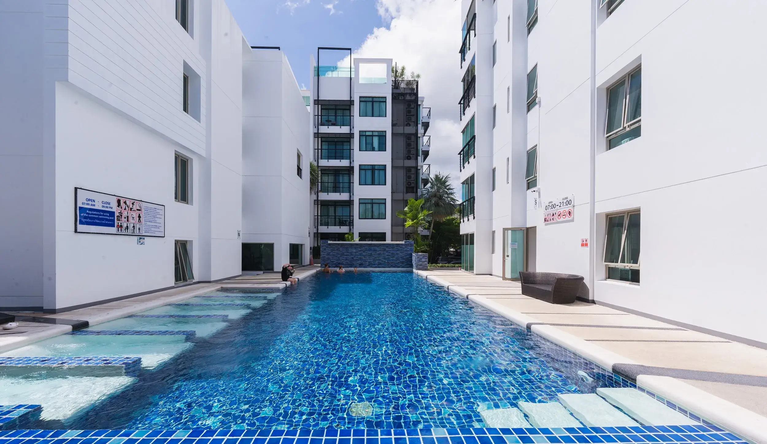 The Regent Condo swimming pool between modern white low-rise buildings in Kamala, Phuket
